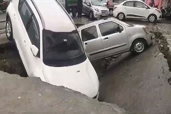 RCC structure of old drain caved in due to rain, two cars stuck in drain